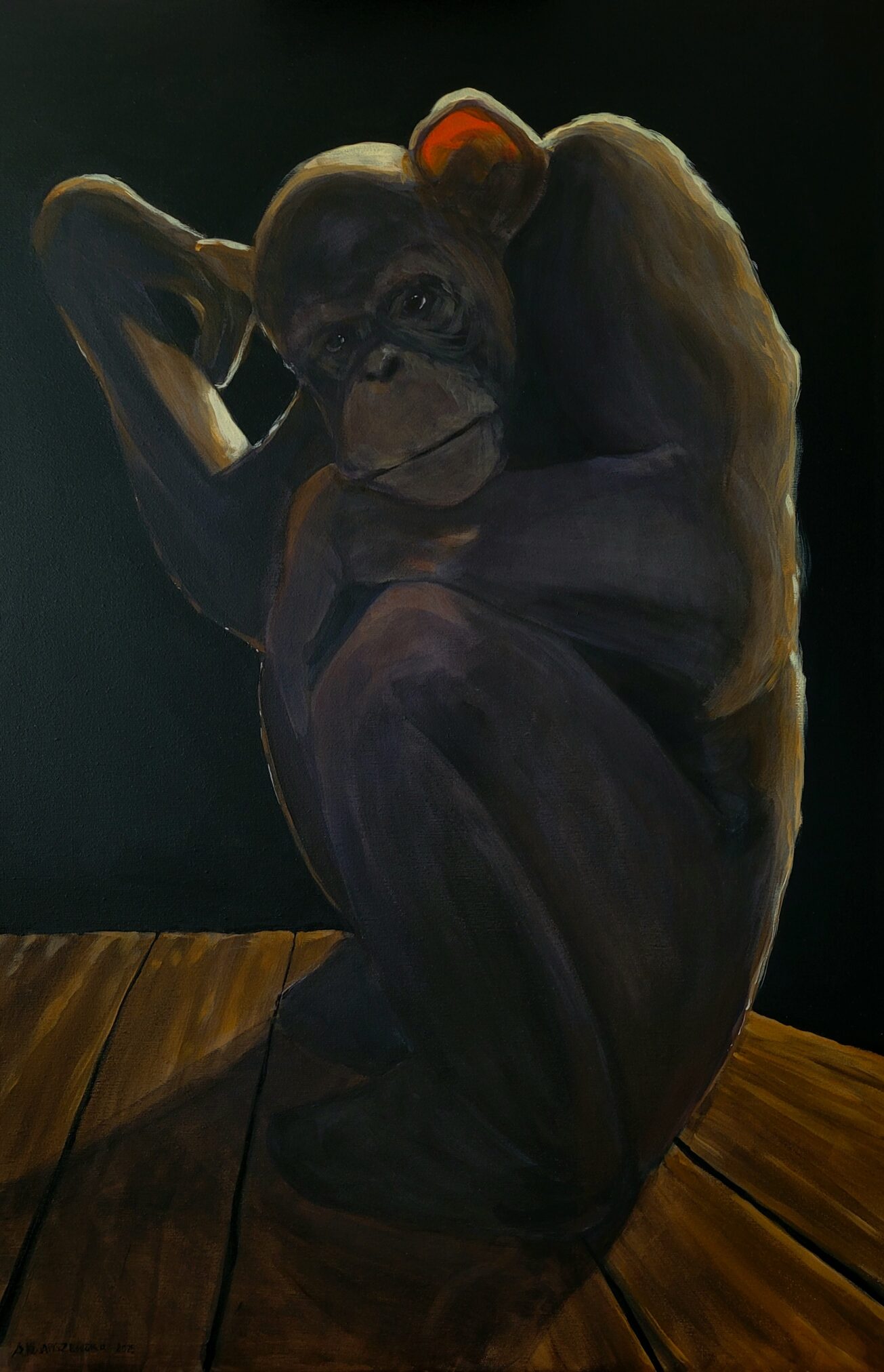 Małpa siedzi w zamyśleniu z ręką podpartą pod głową na drewnianej powierzchni, na ciemnym tle. Na jej głowie widoczny jest pomarańczowy akcent, a postawa przypomina słynną pozę "Myśliciela".